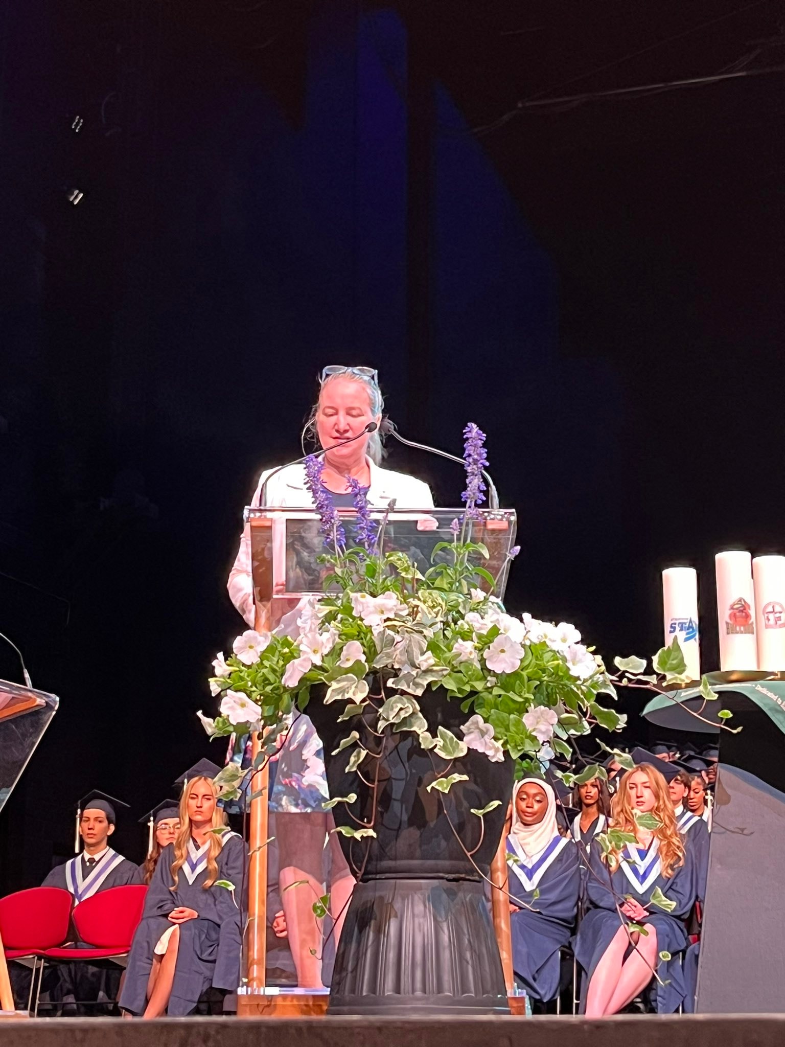Tracey Weiler speaking at a graduation ceremony podium